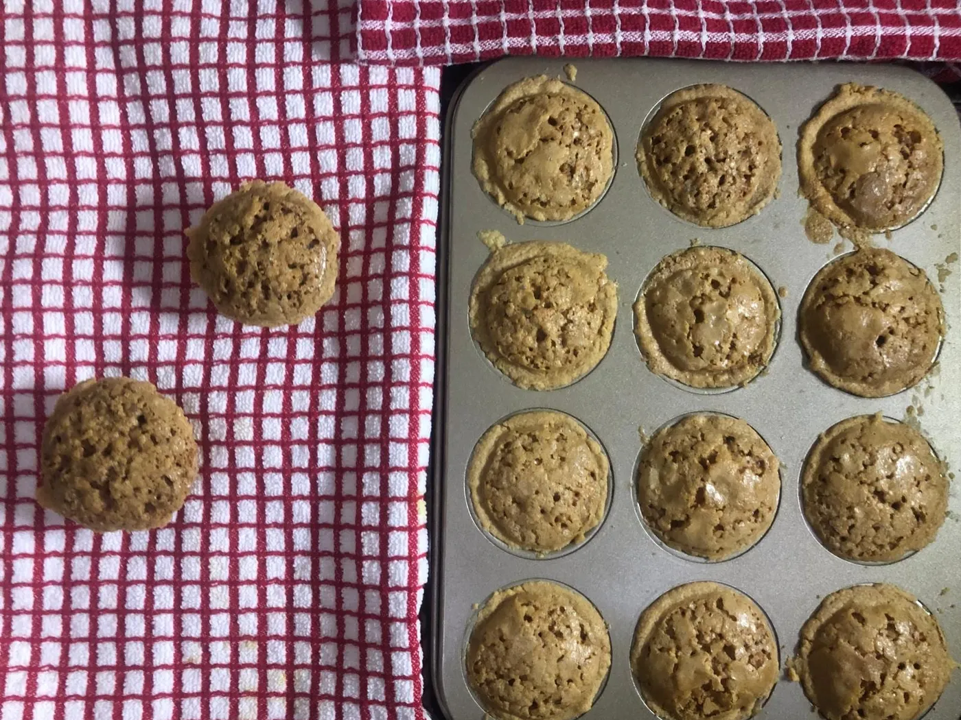 Golden-brown Sri Lankan cheesecake tarts in a 12-cup muffin tin, with two tarts on a red checked cloth