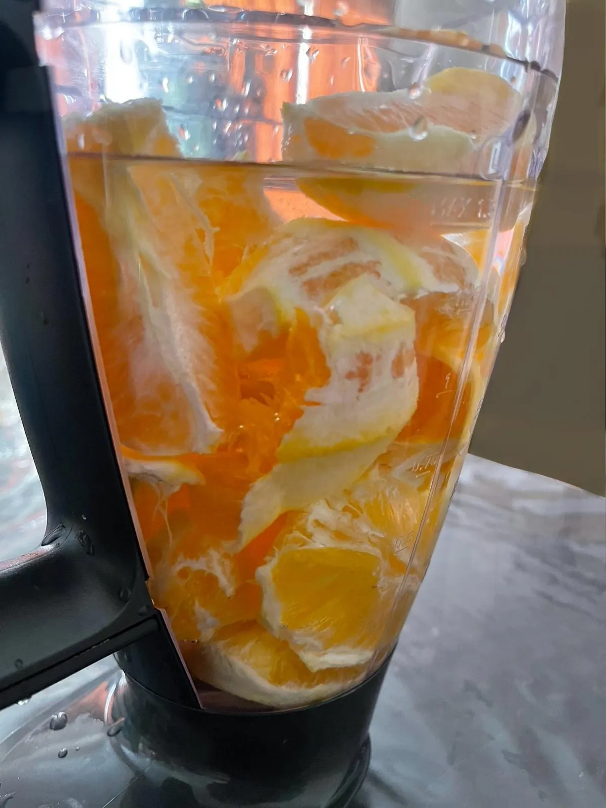 Step 2: Pour in enough drinking water to cover a little more than ¾ of the orange pieces.