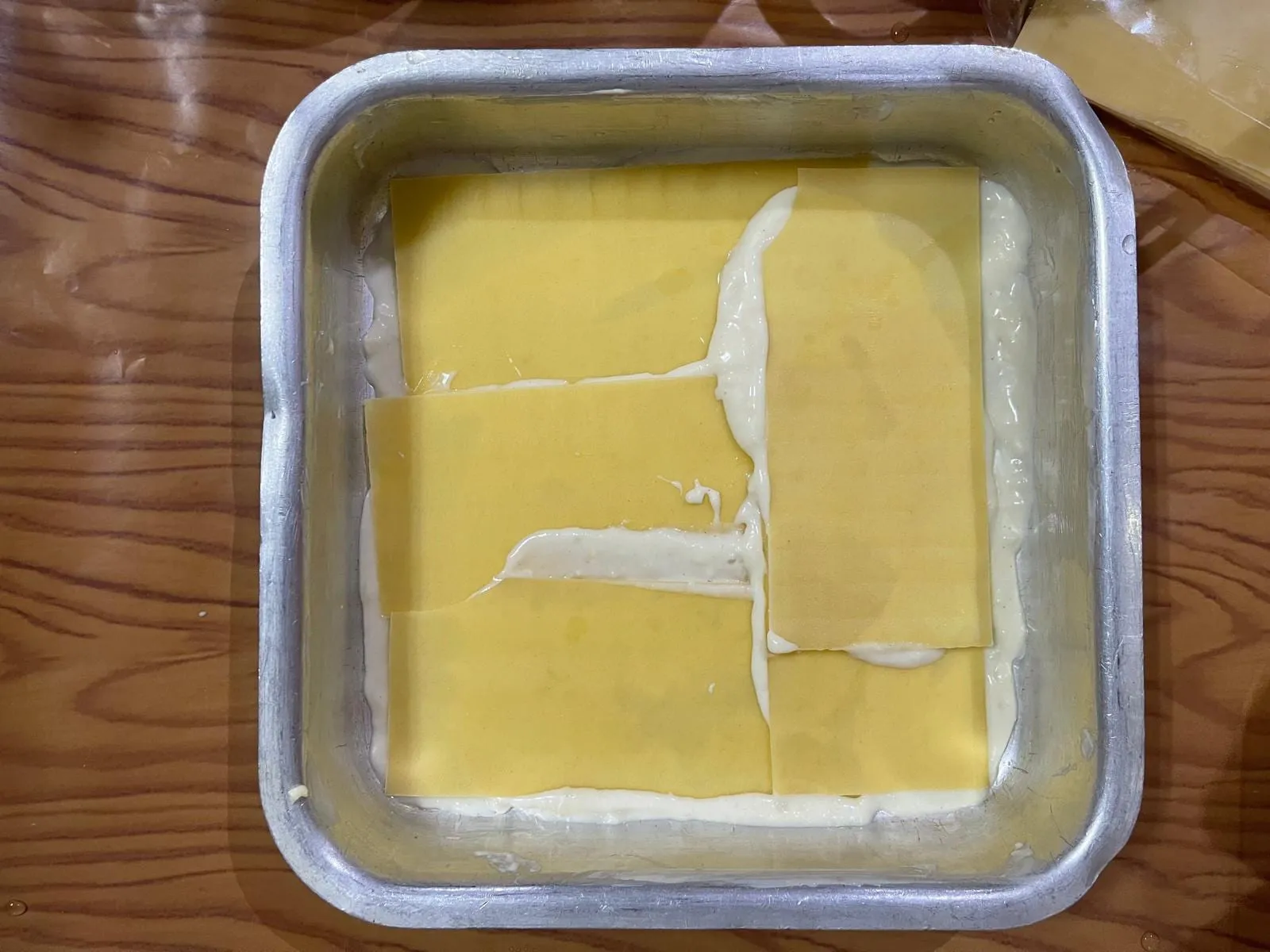 Step 3: Arrange a layer of lasagna sheets over the sauce. If any sheets overlap, spread a little s