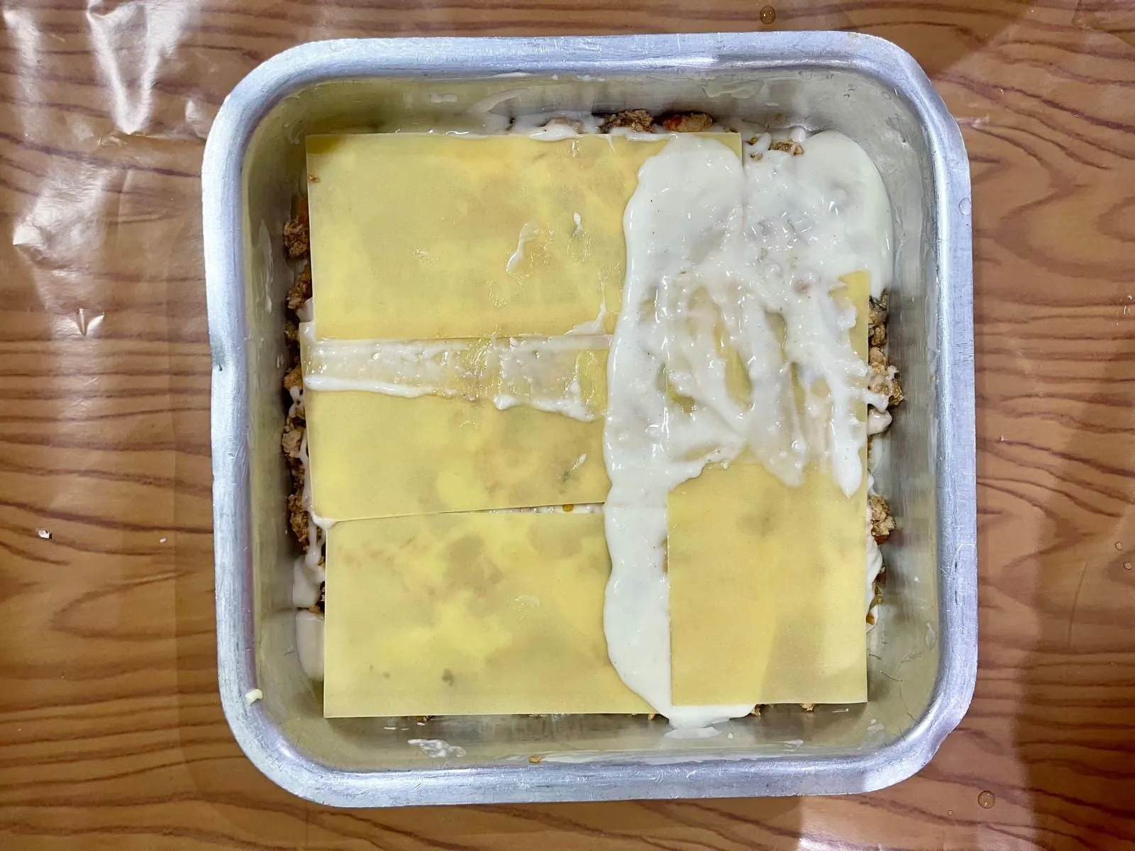 Step 6, photo 1: Continue layering the lasagna sheets, sauce, and meat filling until the dish is nearly ful