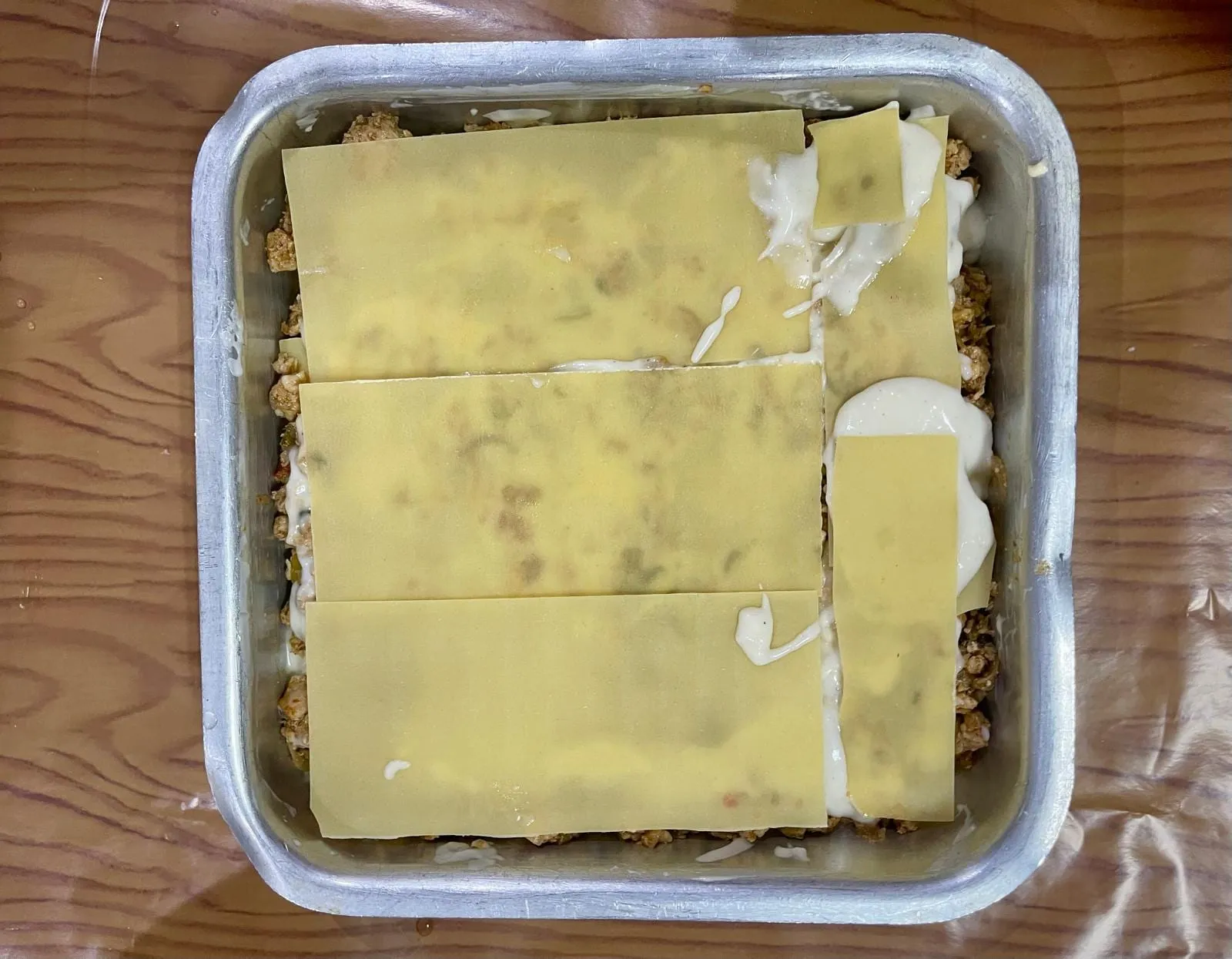Step 7, photo 1: Finish with a final layer of lasagna sheets. Pour the remaining lasagna sauce evenly over 